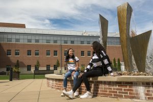 Picture of two students by fountain
